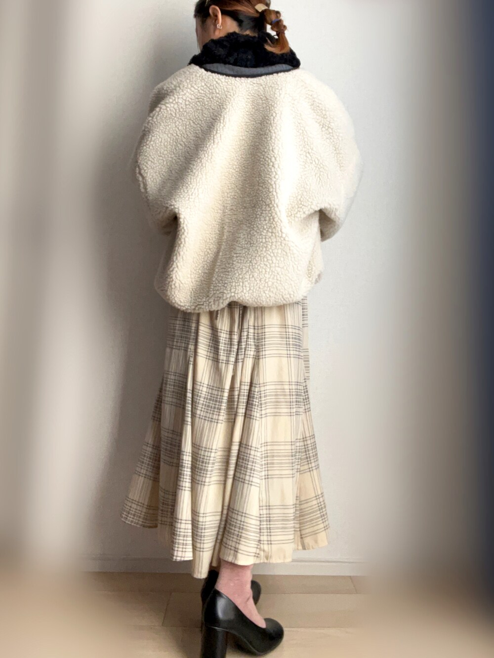 ベージュ系のブルゾン、ホワイト系のスカートを着用したレディースの冬コーディネートの2枚目の写真