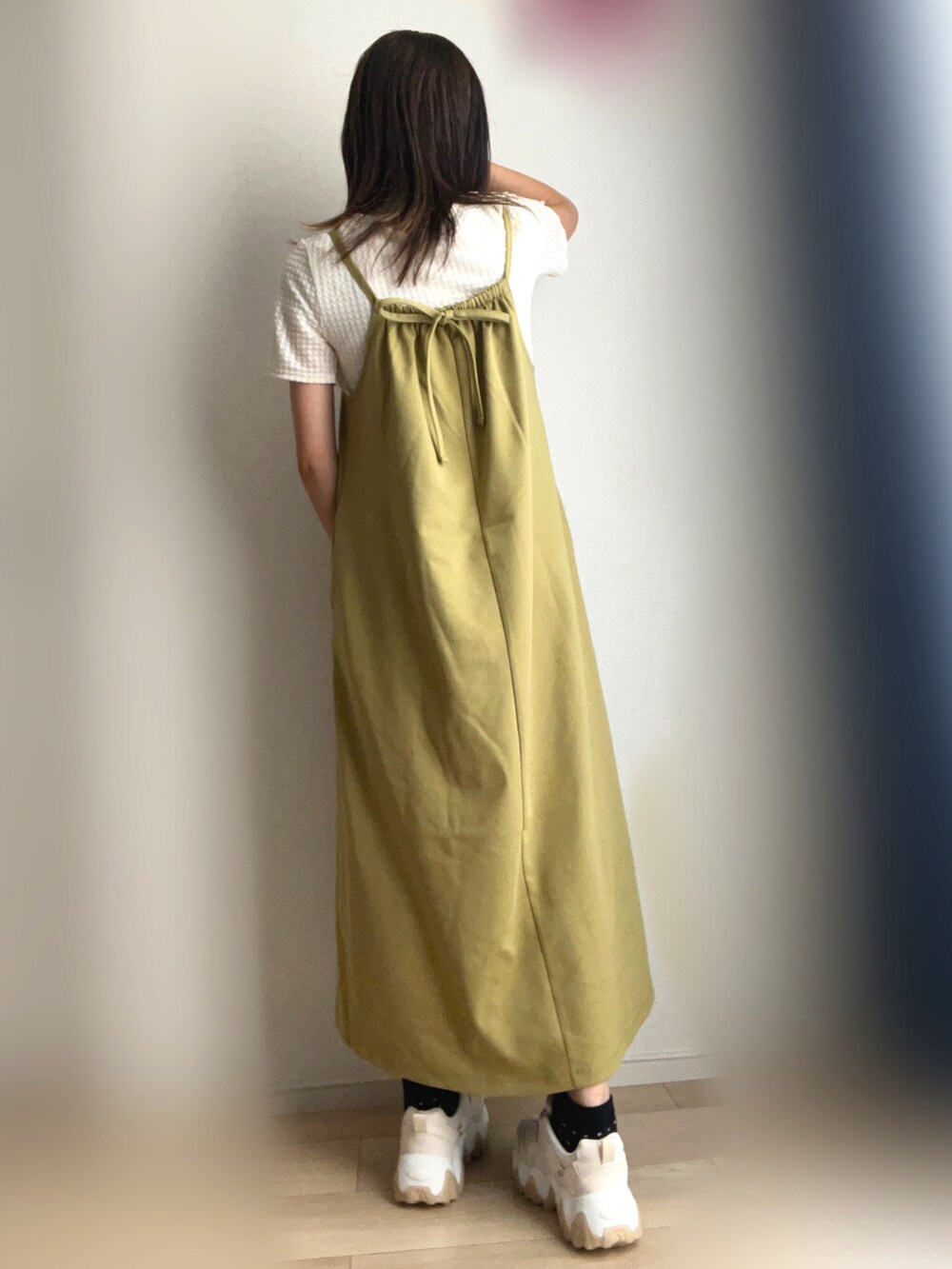 グリーン系のワンピース、ベージュ系のスニーカーを着用したレディースの秋コーディネートの3枚目の写真