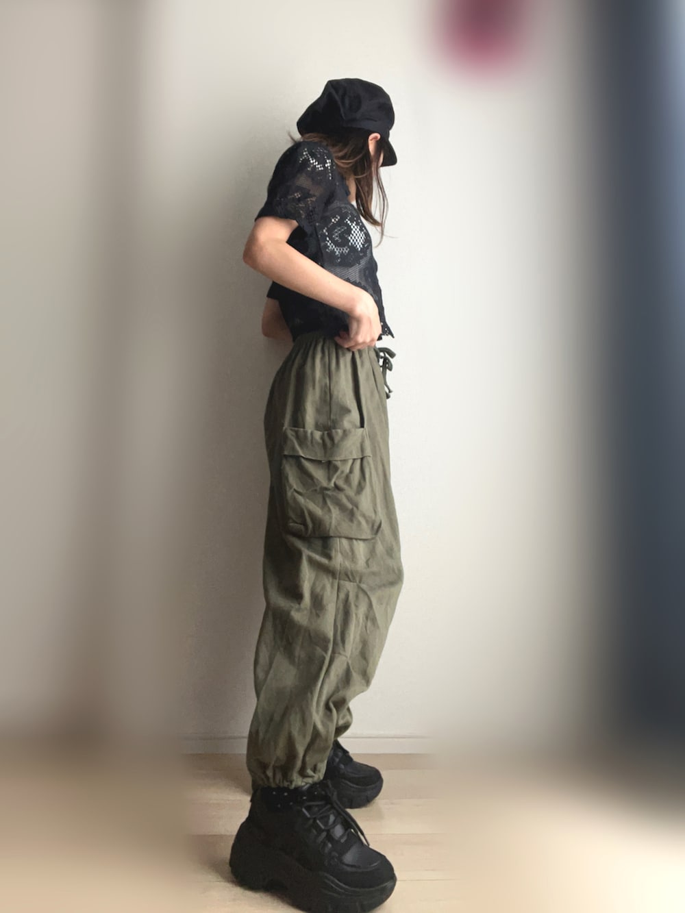 グリーン系のカーゴパンツ、ブラック系のスニーカーを着用したレディースの夏コーディネートの3枚目の写真