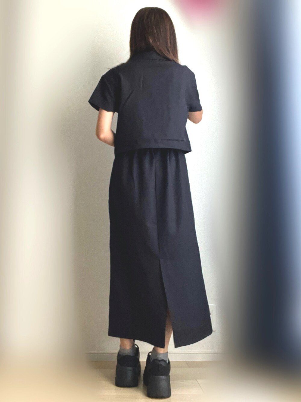 ブラック系のワンピース、ブラック系のスニーカーを着用したレディースの秋コーディネートの4枚目の写真