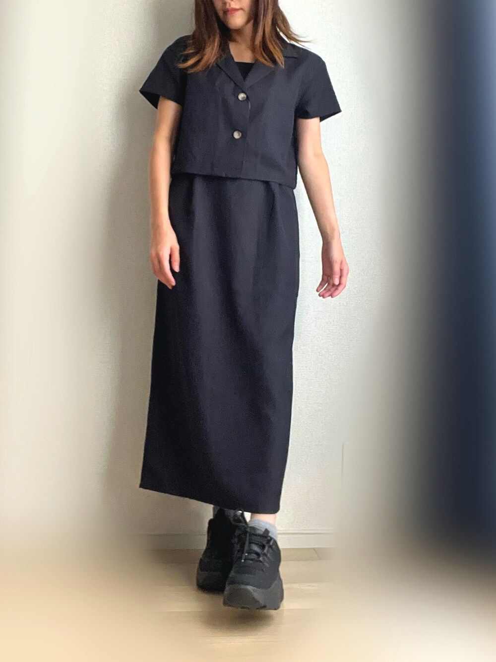 ブラック系のワンピース、ブラック系のスニーカーを着用したレディースの秋コーディネートの3枚目の写真