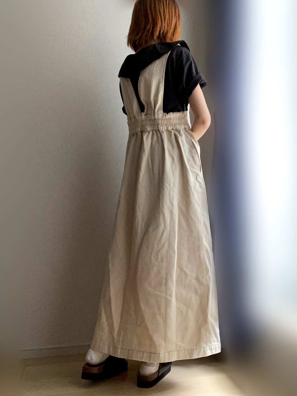 ブラック系のTシャツ/カットソー、ホワイト系のジャンパースカートを着用したレディースの夏コーディネートの2枚目の写真