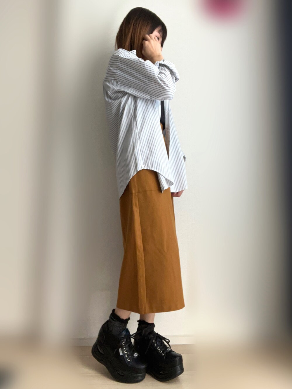 ブラック系のTシャツ/カットソー、ホワイト系のシャツ/ブラウス、ブラウン系のスカートを着用したレディースの秋コーディネートの2枚目の写真