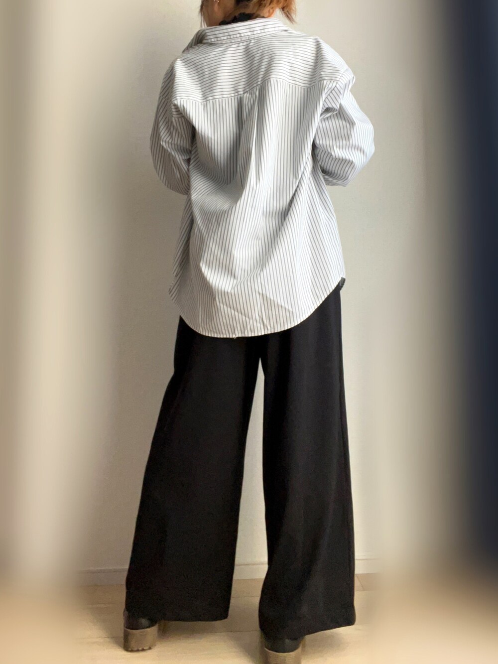 ブラック系のスラックス、ホワイト系のシャツ/ブラウスを着用したレディースの春コーディネートの3枚目の写真