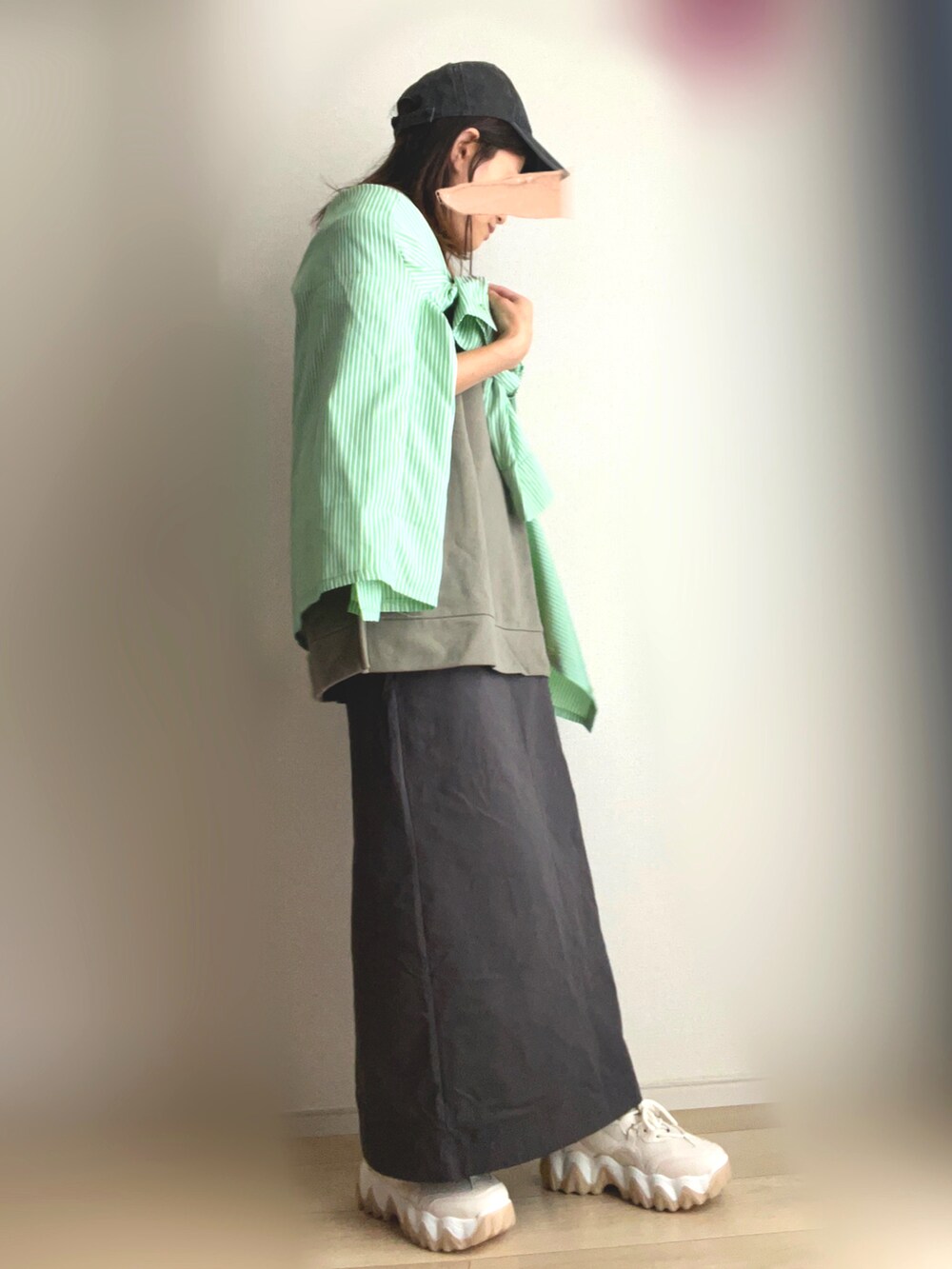ベージュ系のスニーカー、グレー系のスカート、グリーン系のTシャツ/カットソーを着用したレディースの秋コーディネートの3枚目の写真