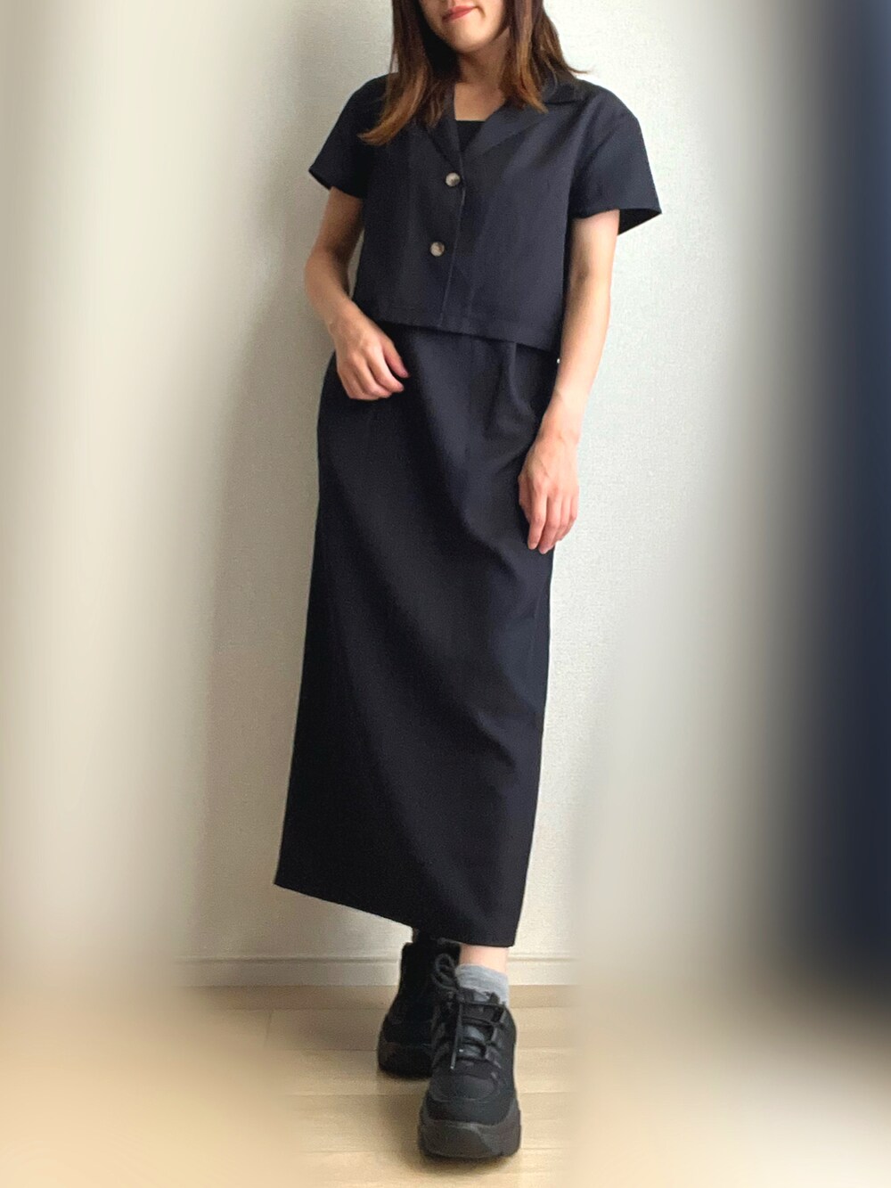 ブラック系のワンピース、ブラック系のスニーカーを着用したレディースの秋コーディネートの2枚目の写真