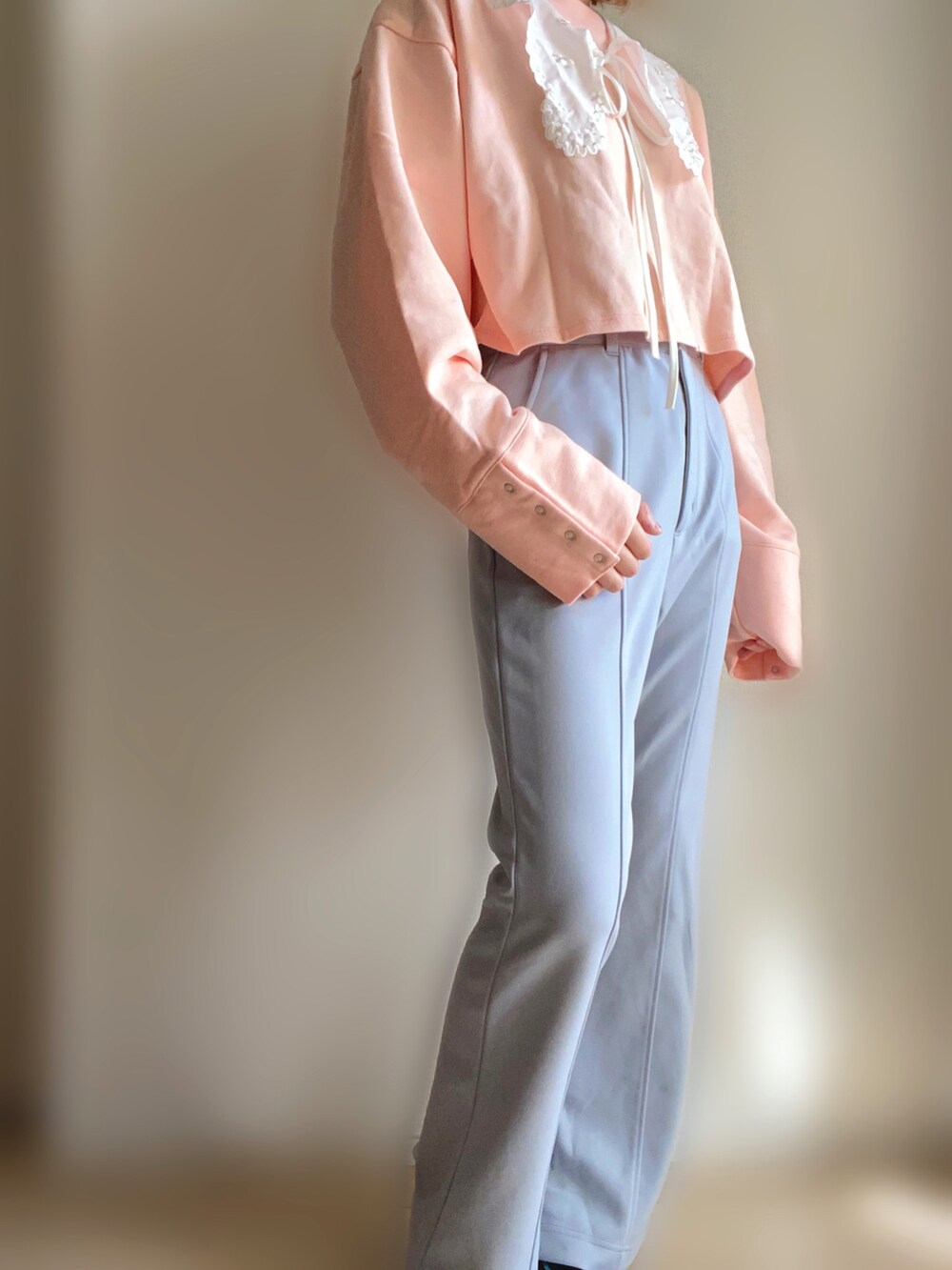 ピンク系のカーディガン/ボレロ、グレー系のその他パンツ、ブラック系のスニーカーを着用したレディースの春コーディネートの3枚目の写真