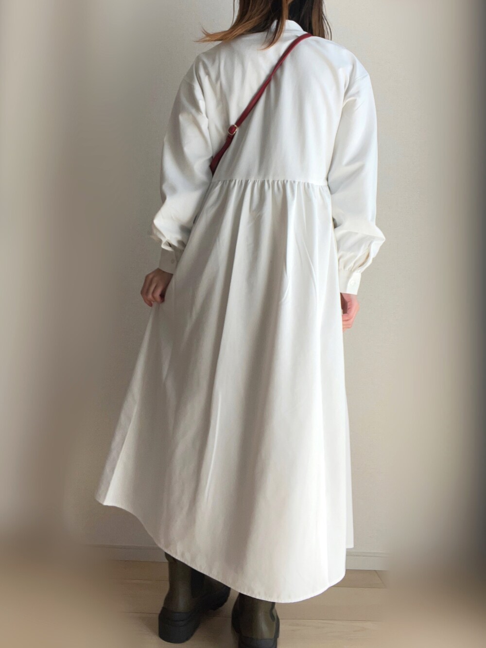 ホワイト系のシャツワンピース、ベージュ系のワンピース、グリーン系のブーツを着用したレディースの春コーディネートの3枚目の写真