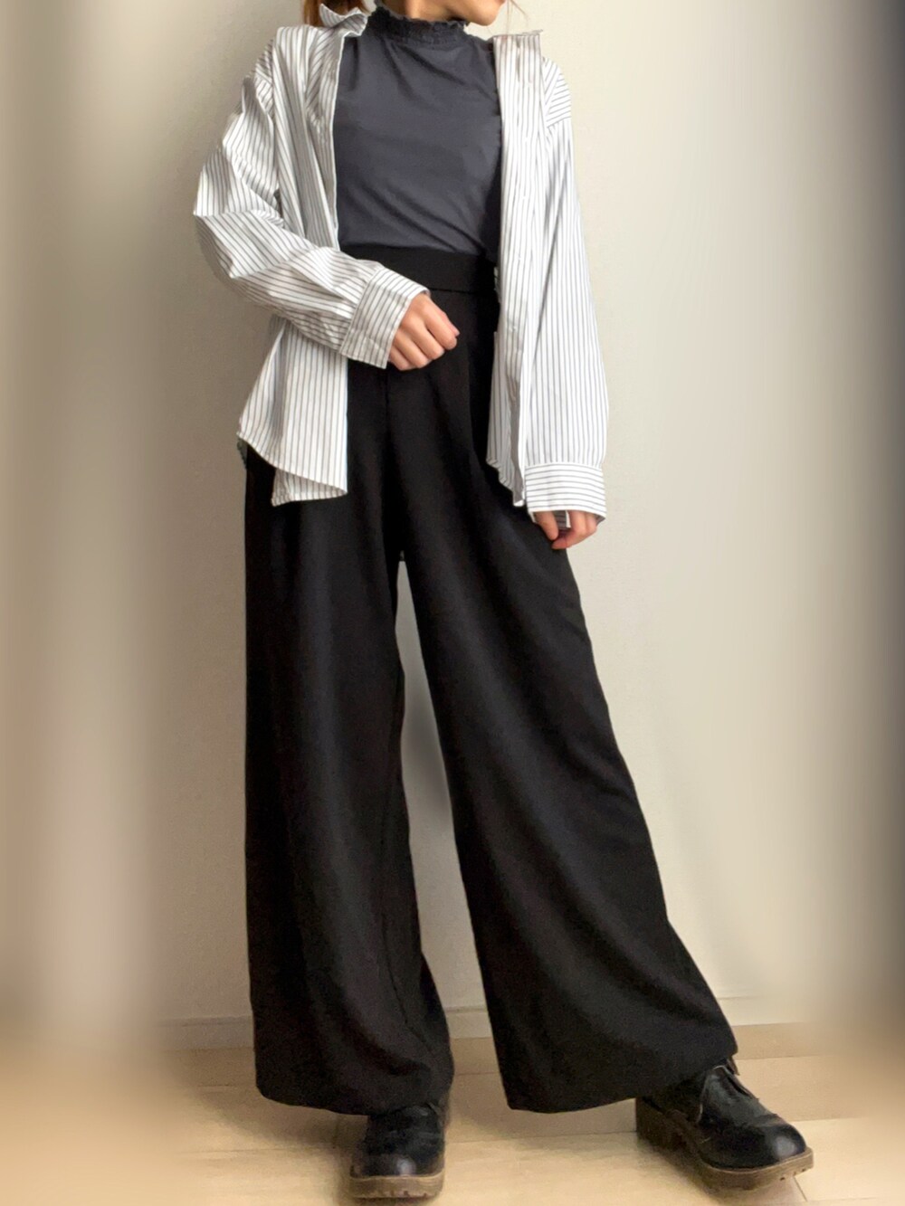 ブラック系のスラックス、ホワイト系のシャツ/ブラウスを着用したレディースの春コーディネートの2枚目の写真