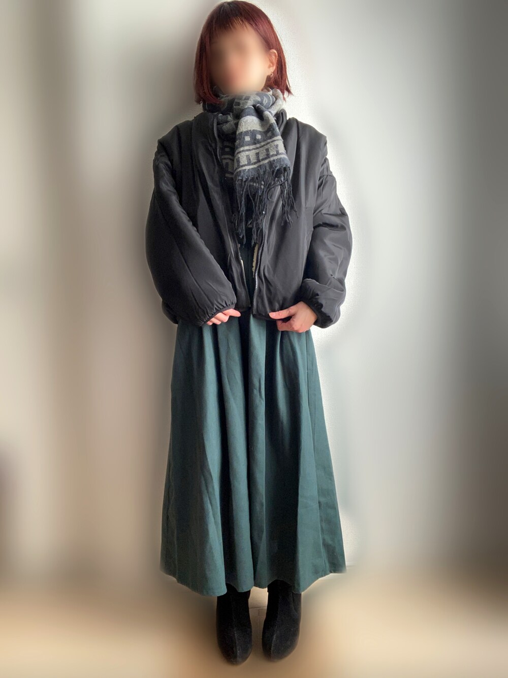 ベージュ系のブルゾン、グリーン系のスカート、グレー系のマフラーを着用したレディースの冬コーディネートの2枚目の写真