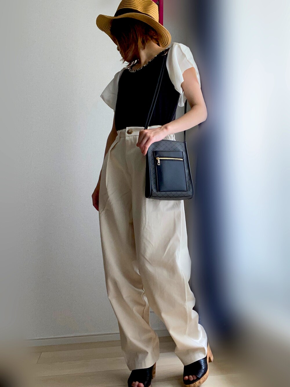 ブラック系のTシャツ/カットソー、ベージュ系のチノパンツを着用したレディースの夏コーディネートの2枚目の写真