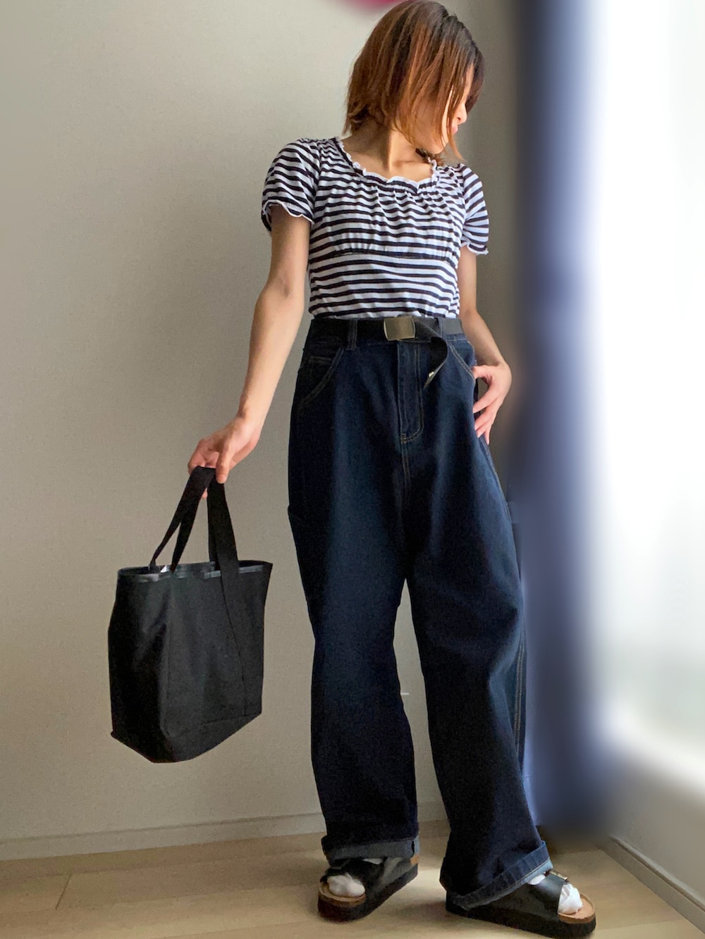 ブルー系のTシャツ/カットソー、ブルー系のデニムパンツ、ブラック系のトートバッグを着用したレディースの夏コーディネートの2枚目の写真