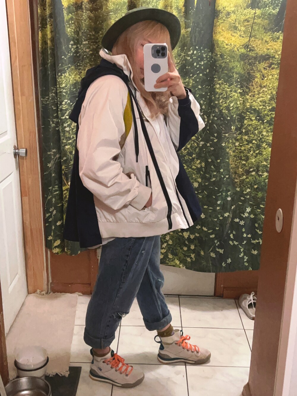 ホワイト系のナイロンジャケット、ブルー系のデニムパンツ、ベージュ系のスニーカーを着用したレディースの冬コーディネートの2枚目の写真