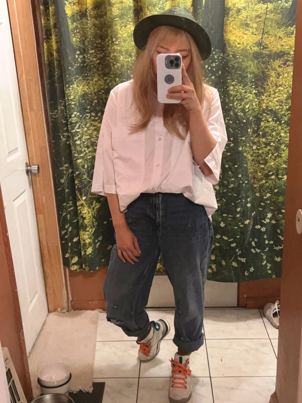 ホワイト系のナイロンジャケット、ブルー系のデニムパンツ、ベージュ系のスニーカーを着用したレディースの冬コーディネートの3枚目の写真