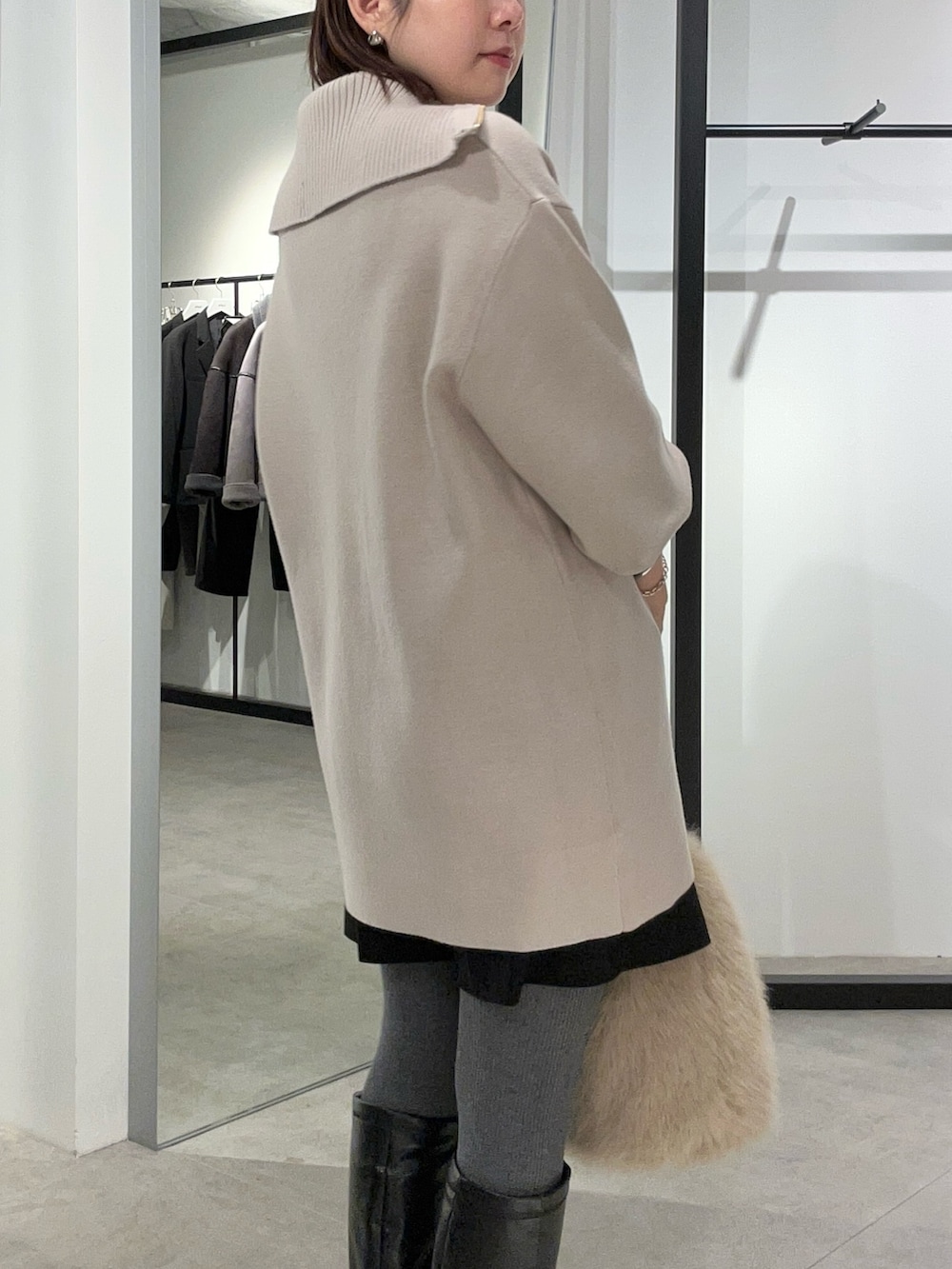 グレー系のニット/セーター、ブラウン系のトートバッグを着用したレディースの冬コーディネートの7枚目の写真