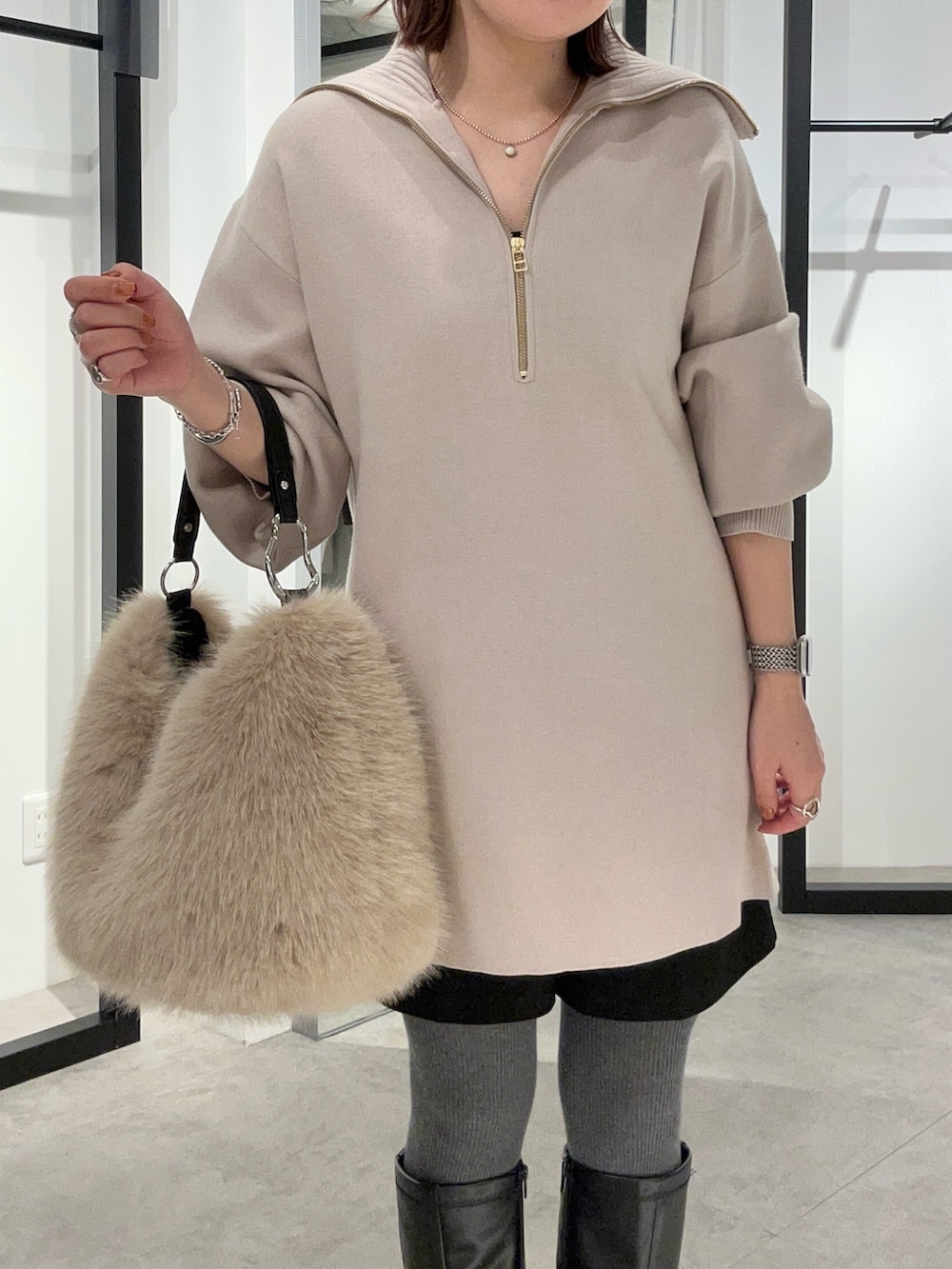 グレー系のニット/セーター、ブラウン系のトートバッグを着用したレディースの冬コーディネートの5枚目の写真