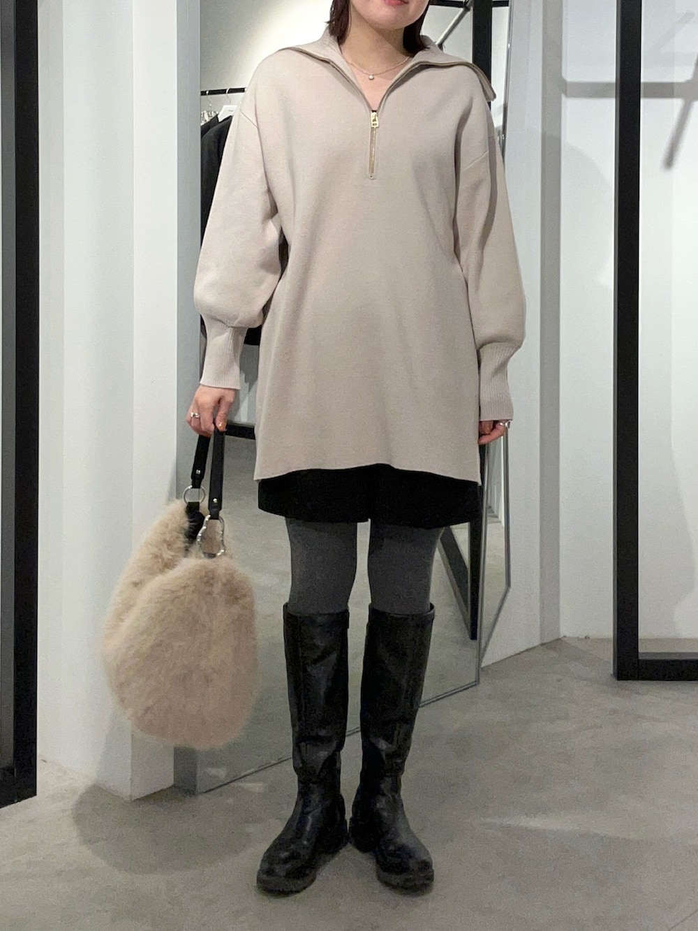 グレー系のニット/セーター、ブラウン系のトートバッグを着用したレディースの冬コーディネートの2枚目の写真