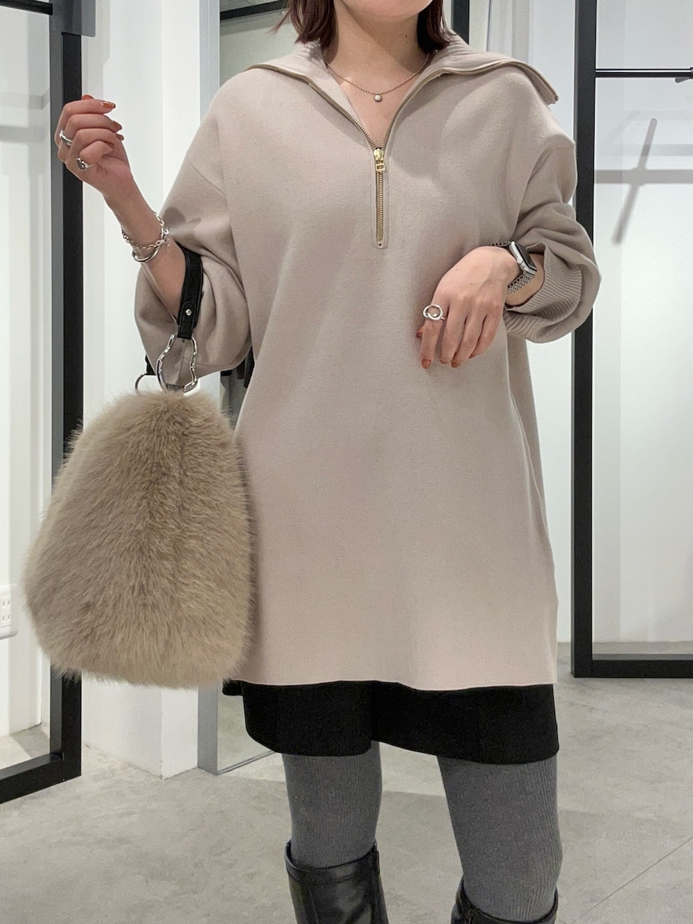 グレー系のニット/セーター、ブラウン系のトートバッグを着用したレディースの冬コーディネートの6枚目の写真