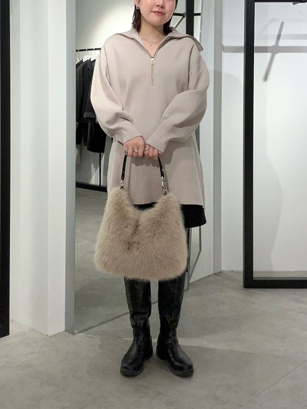 グレー系のニット/セーター、ブラウン系のトートバッグを着用したレディースの冬コーディネートの3枚目の写真