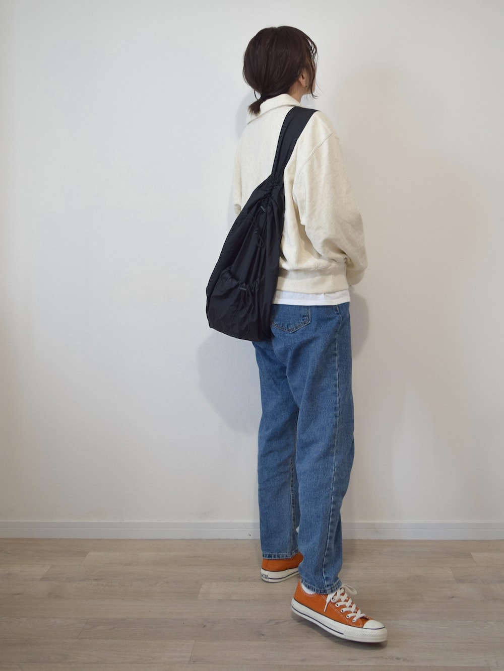 ホワイト系のスウェット、ホワイト系のTシャツ/カットソー、ブルー系のデニムパンツを着用したレディースの秋コーディネートの2枚目の写真