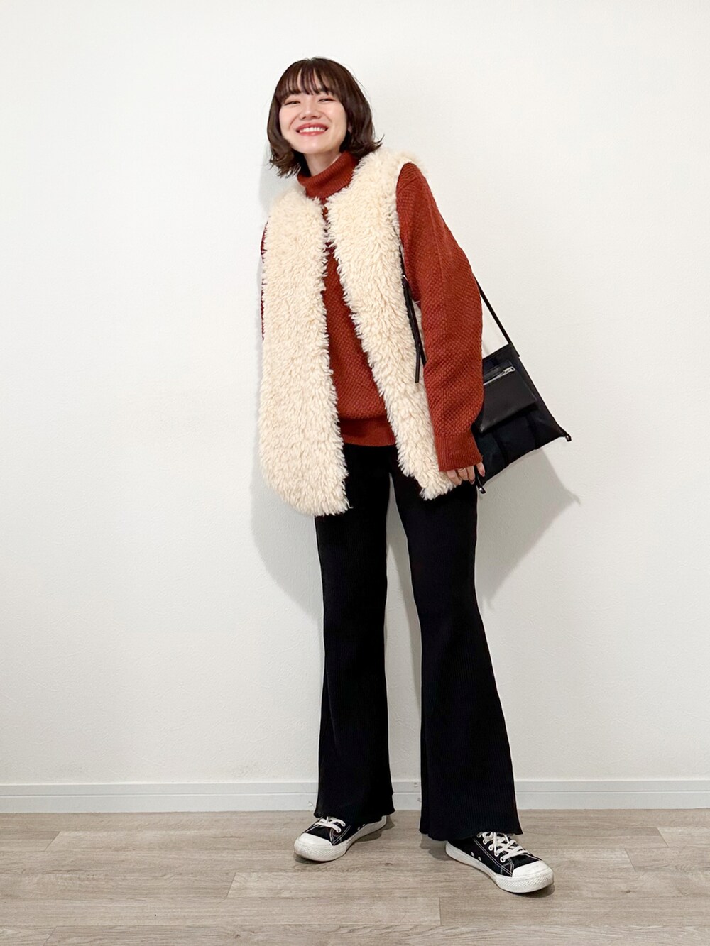 オレンジ系のニット/セーター、ブラック系のスウェットパンツ、ブラック系のモッズコートを着用したレディースの冬コーディネートの3枚目の写真