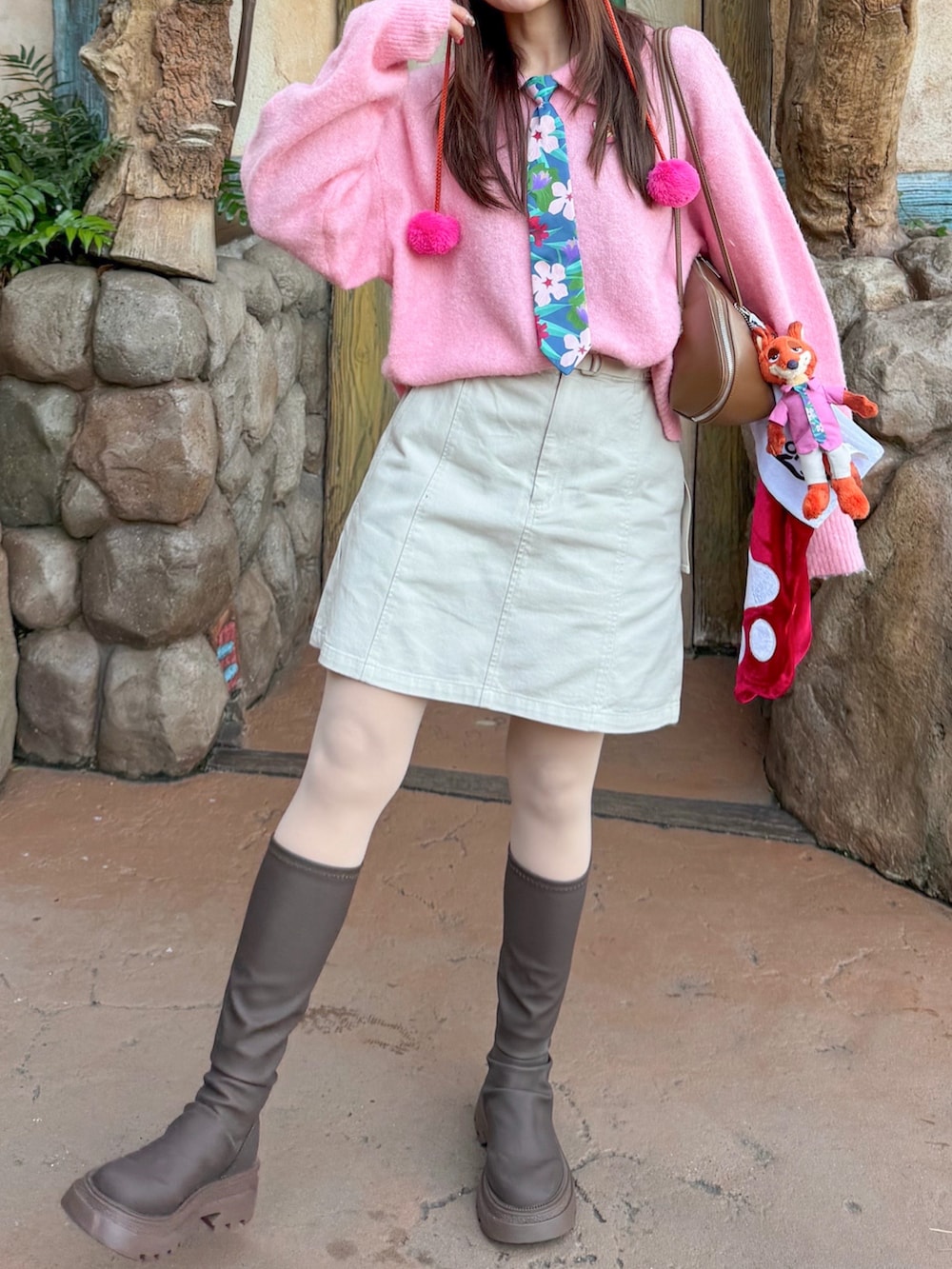 ピンク系のカーディガン/ボレロ、ホワイト系のスカート、ブラウン系のブルゾンを着用したレディースの冬コーディネートの2枚目の写真