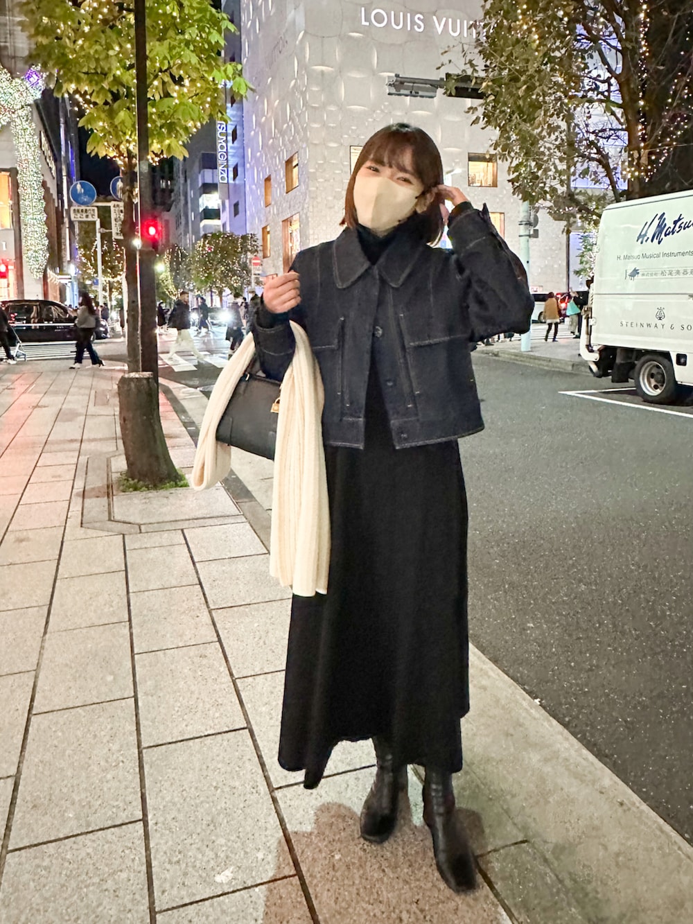 ブルー系のデニムジャケット、ブラック系のワンピース、ブラック系のバッグを着用したレディースの冬コーディネートの3枚目の写真