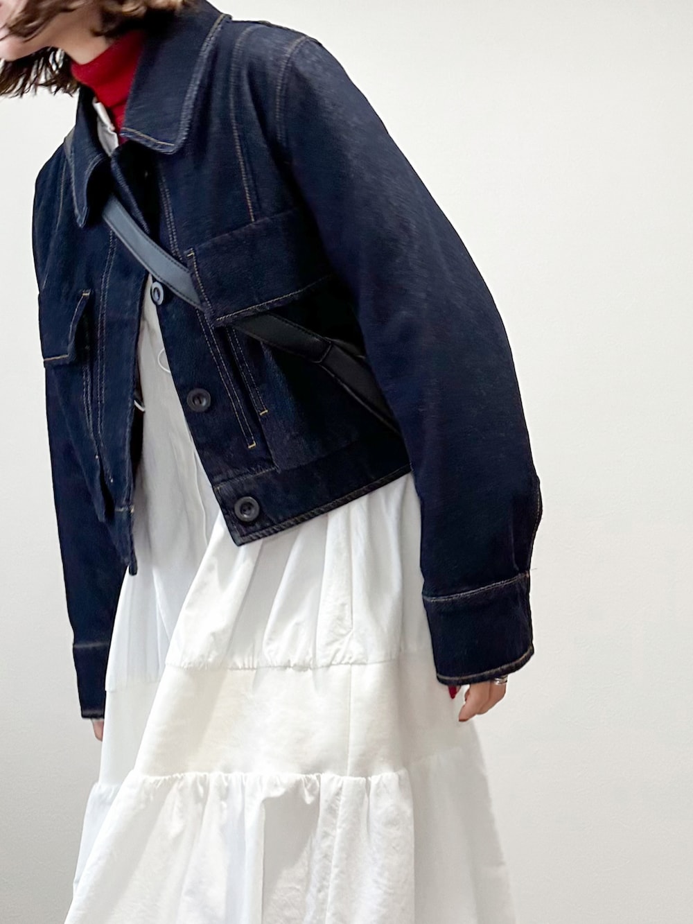 レッド系のニット/セーター、ホワイト系のワンピース、ブルー系のデニムジャケットを着用したレディースの冬コーディネートの4枚目の写真