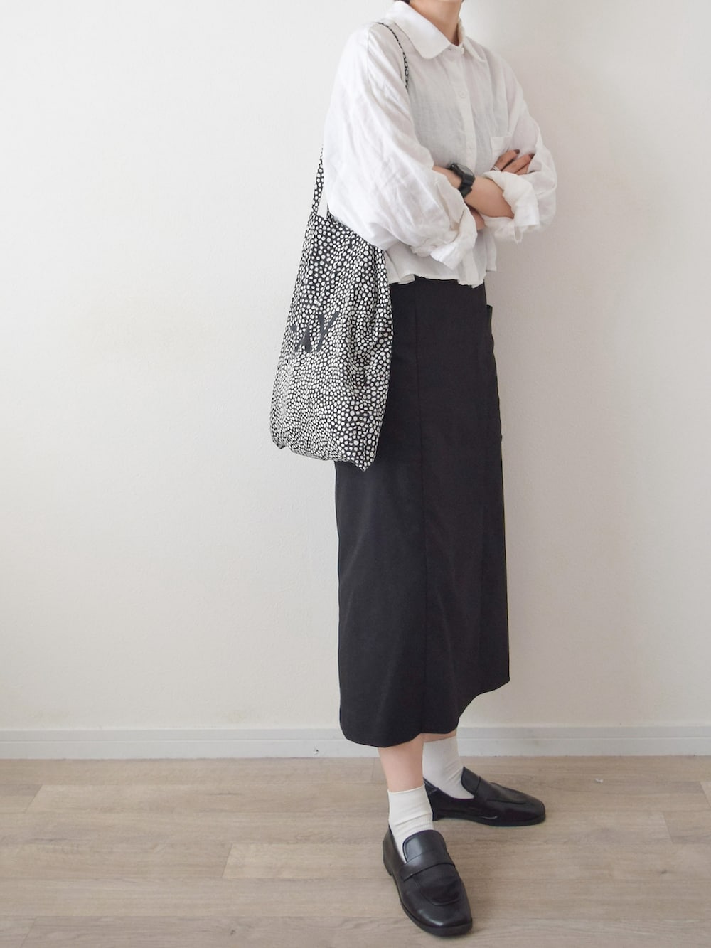 ホワイト系のシャツ/ブラウス、ブラック系のスカート、ブラック系のトートバッグを着用したレディースの夏コーディネートの2枚目の写真