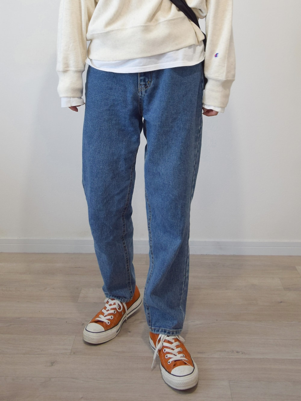 ホワイト系のスウェット、ホワイト系のTシャツ/カットソー、ブルー系のデニムパンツを着用したレディースの秋コーディネートの3枚目の写真