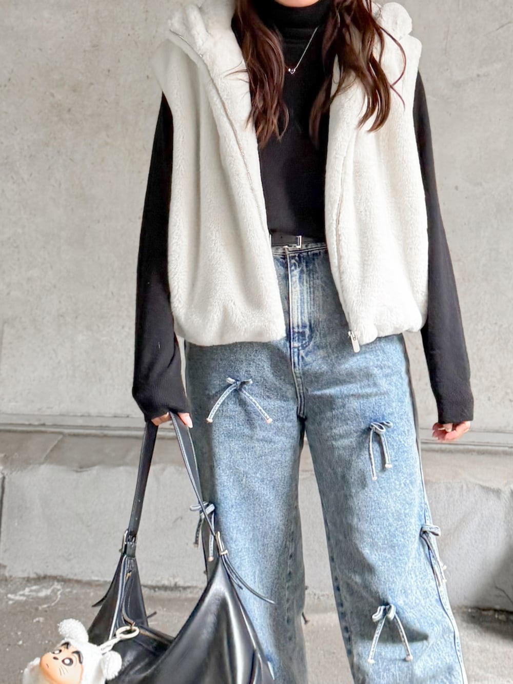 ホワイト系のその他アウター、ブラック系のニット/セーター、ブルー系のデニムパンツを着用したレディースの秋コーディネートの3枚目の写真