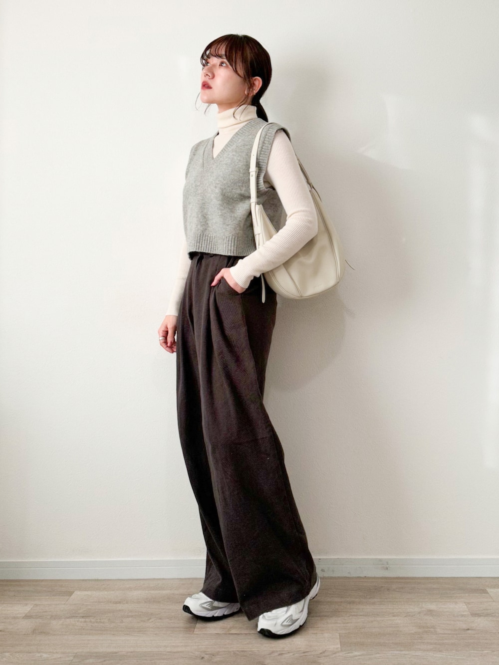 ホワイト系のニット/セーター、グレー系のベスト、ブラック系のその他パンツを着用したレディースの冬コーディネートの2枚目の写真