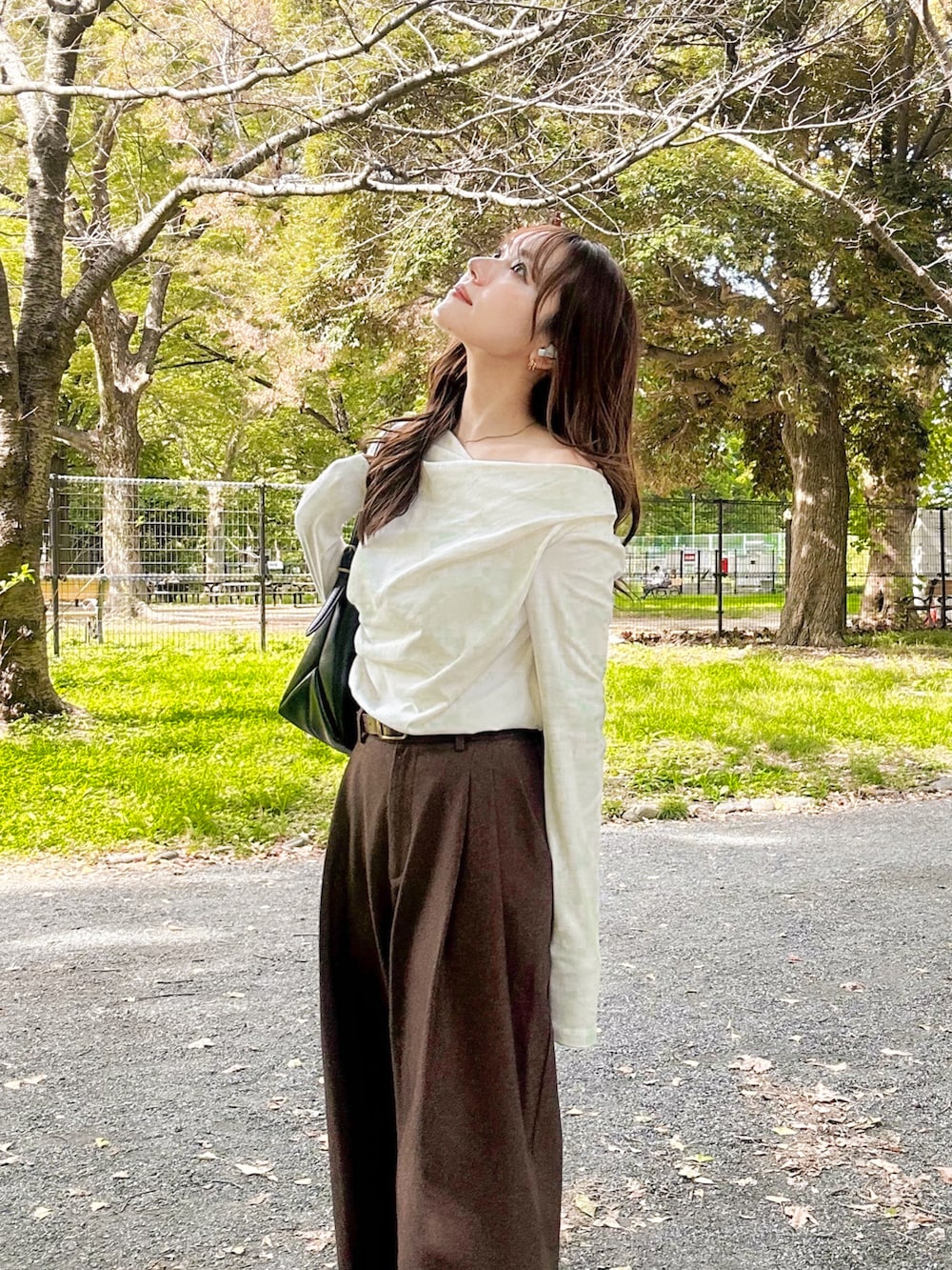 ホワイト系のTシャツ/カットソー、ブラウン系のスラックス、ブラック系のショルダーバッグを着用したレディースの秋コーディネートの5枚目の写真