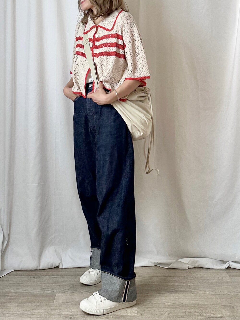 ホワイト系のニット/セーター、ホワイト系のタンクトップ、ブルー系のデニムパンツを着用したレディースの夏コーディネートの2枚目の写真