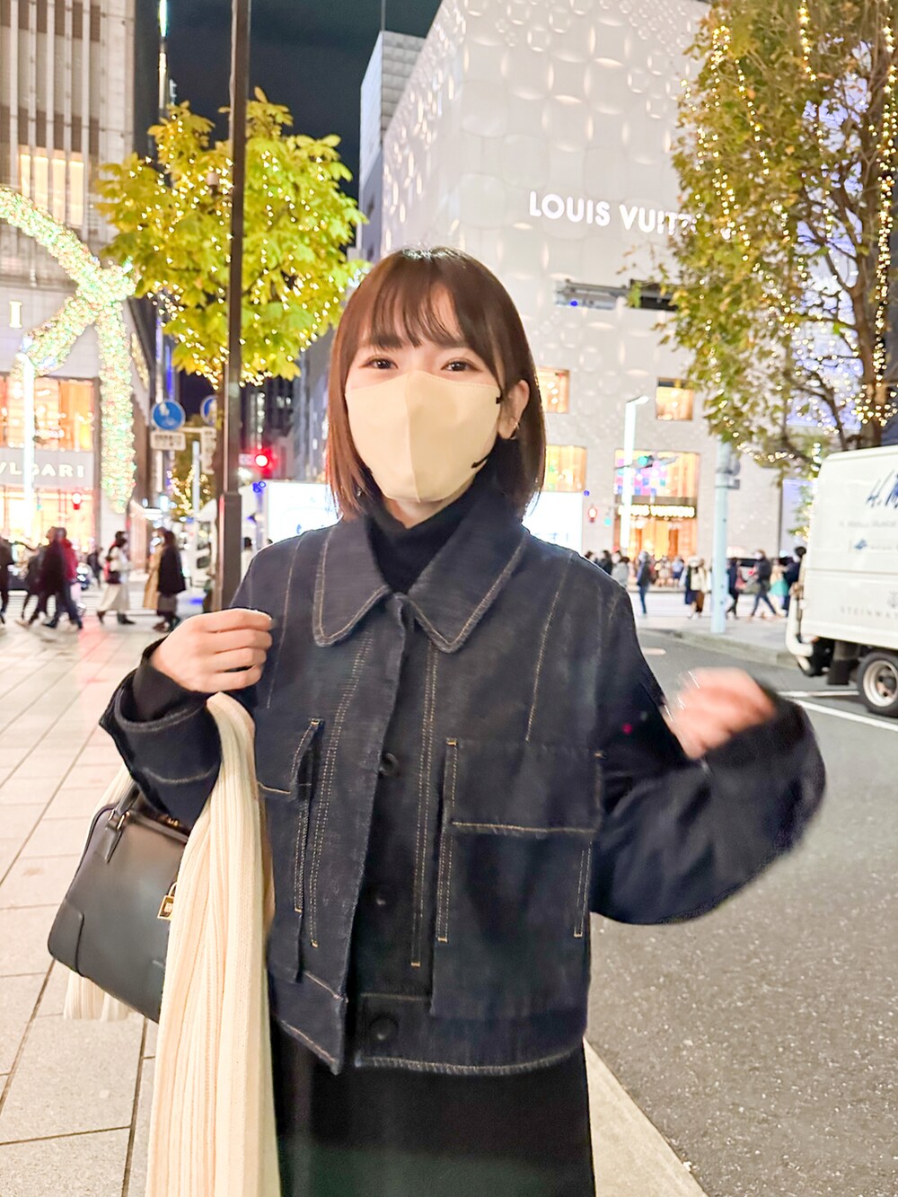 ブルー系のデニムジャケット、ブラック系のワンピース、ブラック系のバッグを着用したレディースの冬コーディネートの2枚目の写真