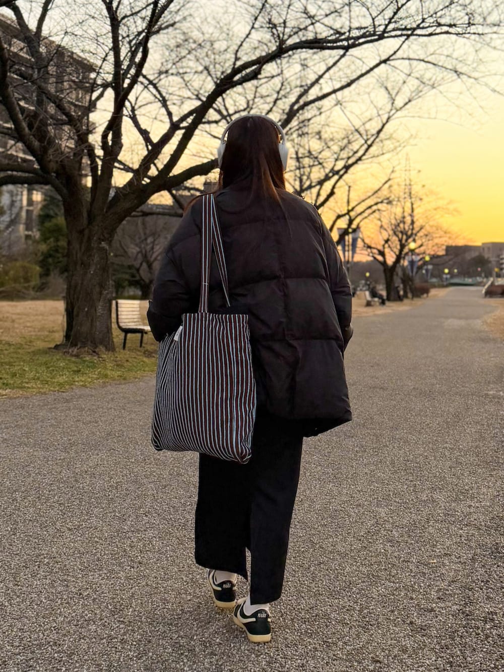 ブラック系のダウンジャケット/コート、ホワイト系のニット/セーター、ブラック系のスカートを着用したレディースの冬コーディネートの4枚目の写真