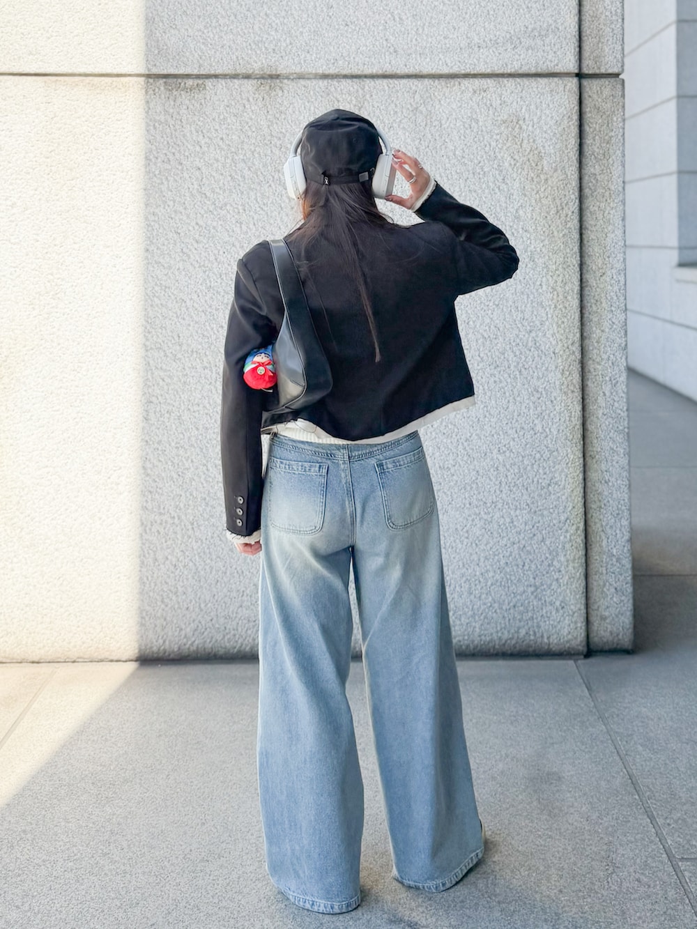 ベージュ系のカーディガン/ボレロ、ブルー系のデニムパンツ、ブラック系のテーラードジャケットを着用したレディースの春コーディネートの3枚目の写真