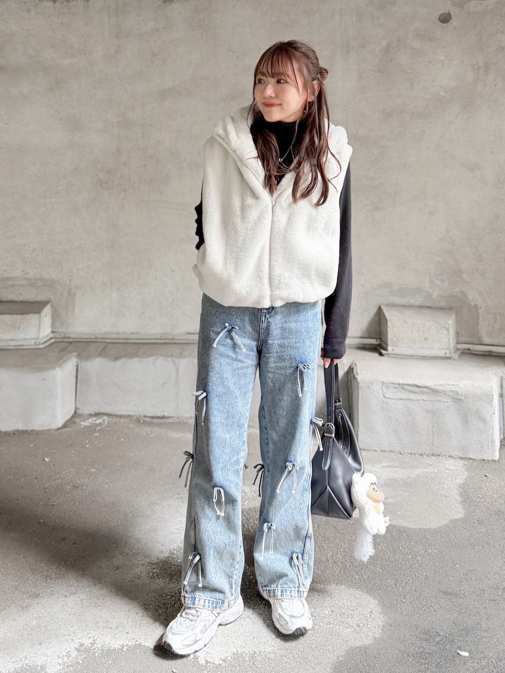 ホワイト系のその他アウター、ブラック系のニット/セーター、ブルー系のデニムパンツを着用したレディースの秋コーディネートの2枚目の写真
