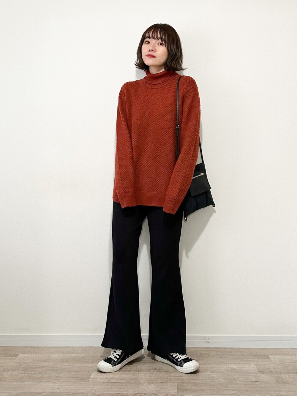 オレンジ系のニット/セーター、ブラック系のスウェットパンツ、ブラック系のモッズコートを着用したレディースの冬コーディネートの4枚目の写真