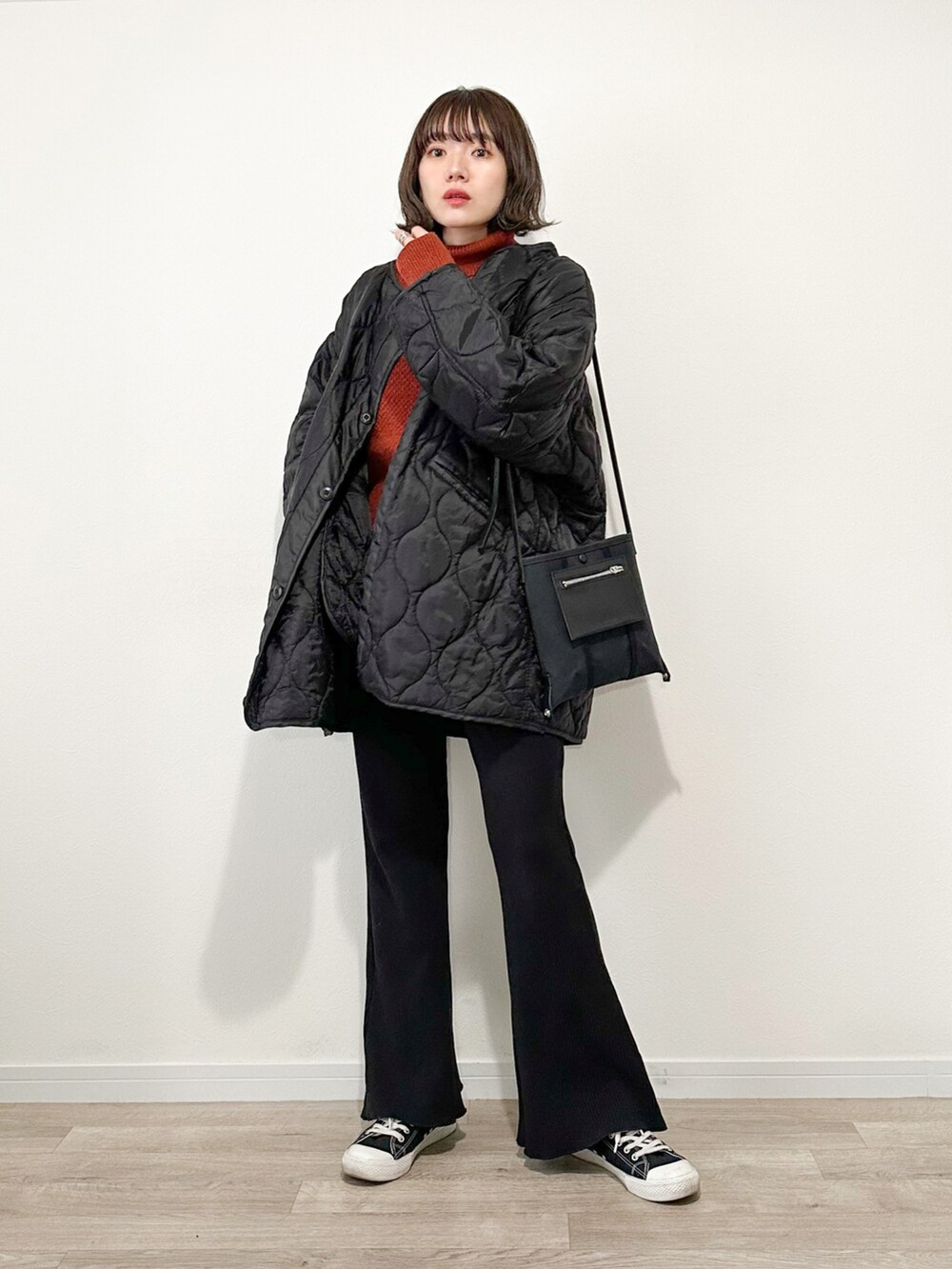 オレンジ系のニット/セーター、ブラック系のスウェットパンツ、ブラック系のモッズコートを着用したレディースの冬コーディネートの2枚目の写真