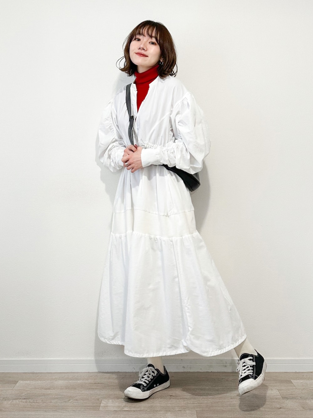 レッド系のニット/セーター、ホワイト系のワンピース、ブルー系のデニムジャケットを着用したレディースの冬コーディネートの3枚目の写真