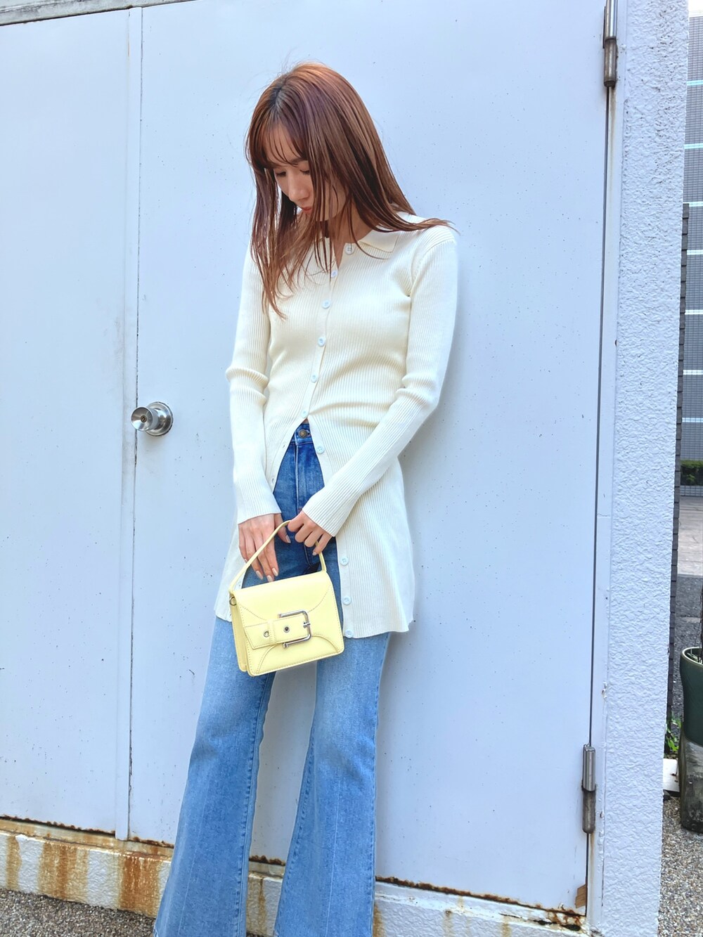 ホワイト系のワンピース、ブルー系のデニムパンツ、シルバー系のパンプスを着用したレディースの冬コーディネートの2枚目の写真