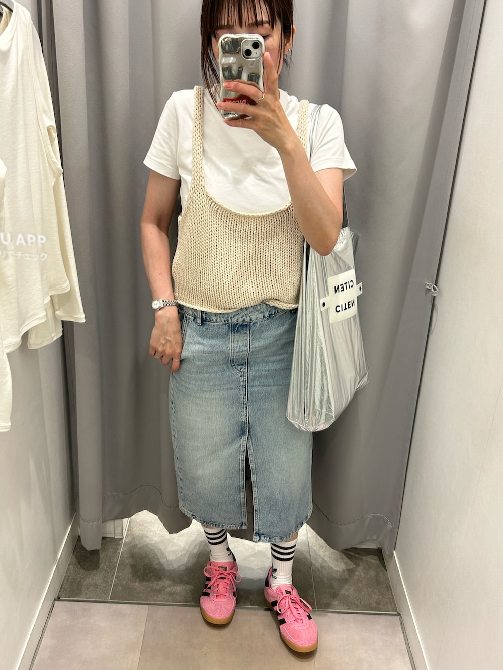ホワイト系のベスト、シルバー系のトートバッグ、ピンク系のスニーカーを着用したレディースの春コーディネートの2枚目の写真