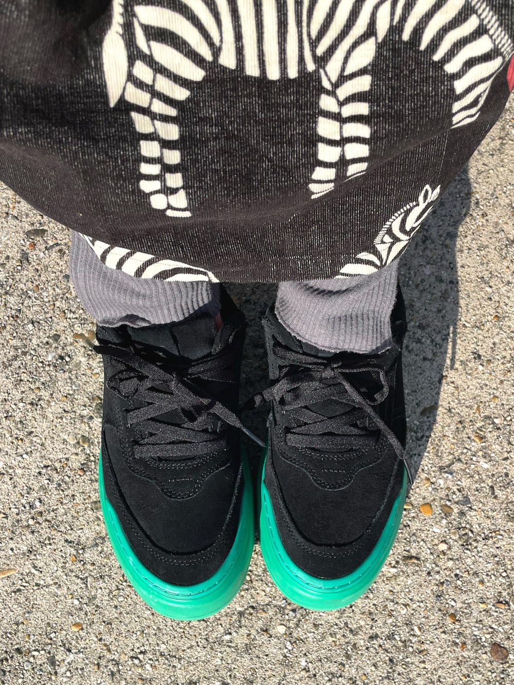 ブラック系のスカート、ブラック系のスニーカーを着用したレディースの秋コーディネートの3枚目の写真