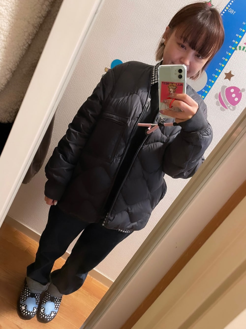 ブラック系のスウェット、ブラック系のデニムパンツ、ブラック系のスニーカーを着用したレディースの冬コーディネートの4枚目の写真