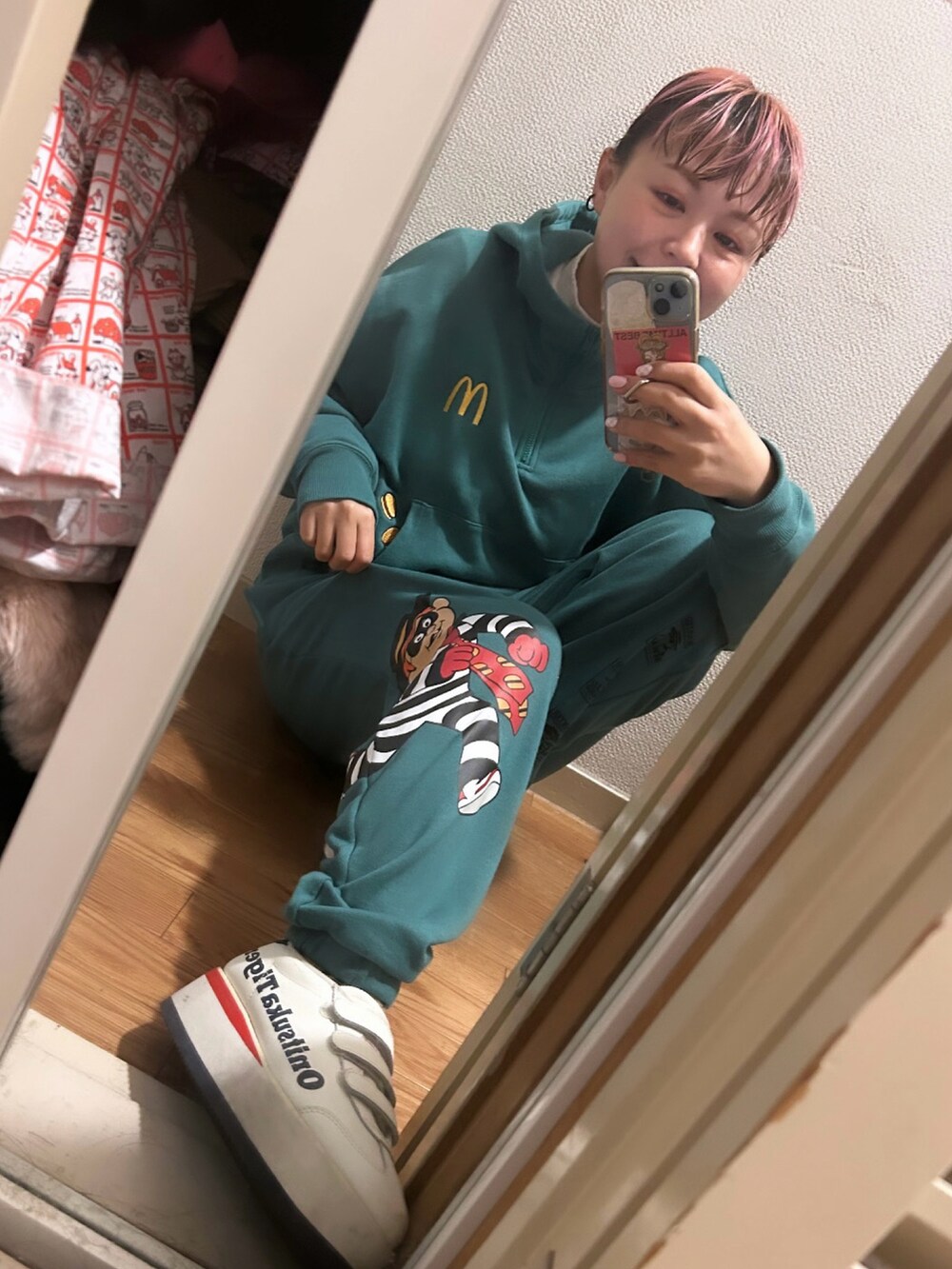 グリーン系のスウェット、グリーン系のスウェットパンツ、ベージュ系のスニーカーを着用したレディースの冬コーディネートの2枚目の写真