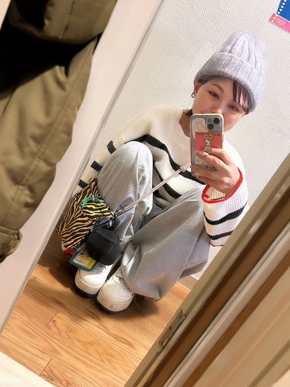 ホワイト系のニット/セーター、グレー系のスウェットパンツ、ベージュ系のスニーカーを着用したレディースの冬コーディネートの3枚目の写真