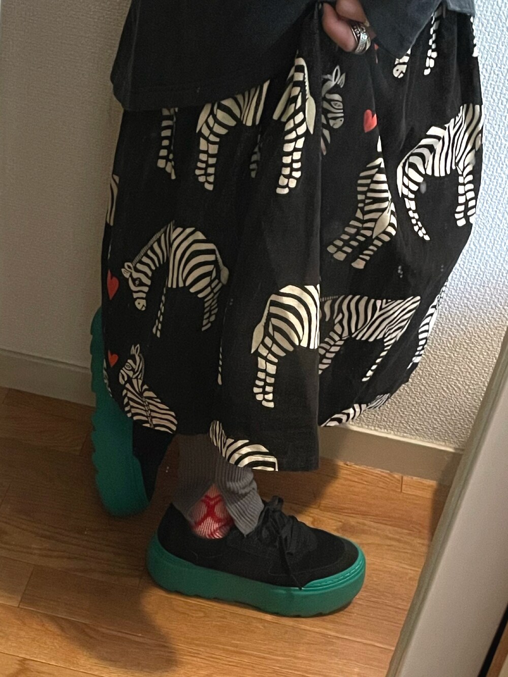 ブラック系のスカート、ブラック系のスニーカーを着用したレディースの秋コーディネートの2枚目の写真