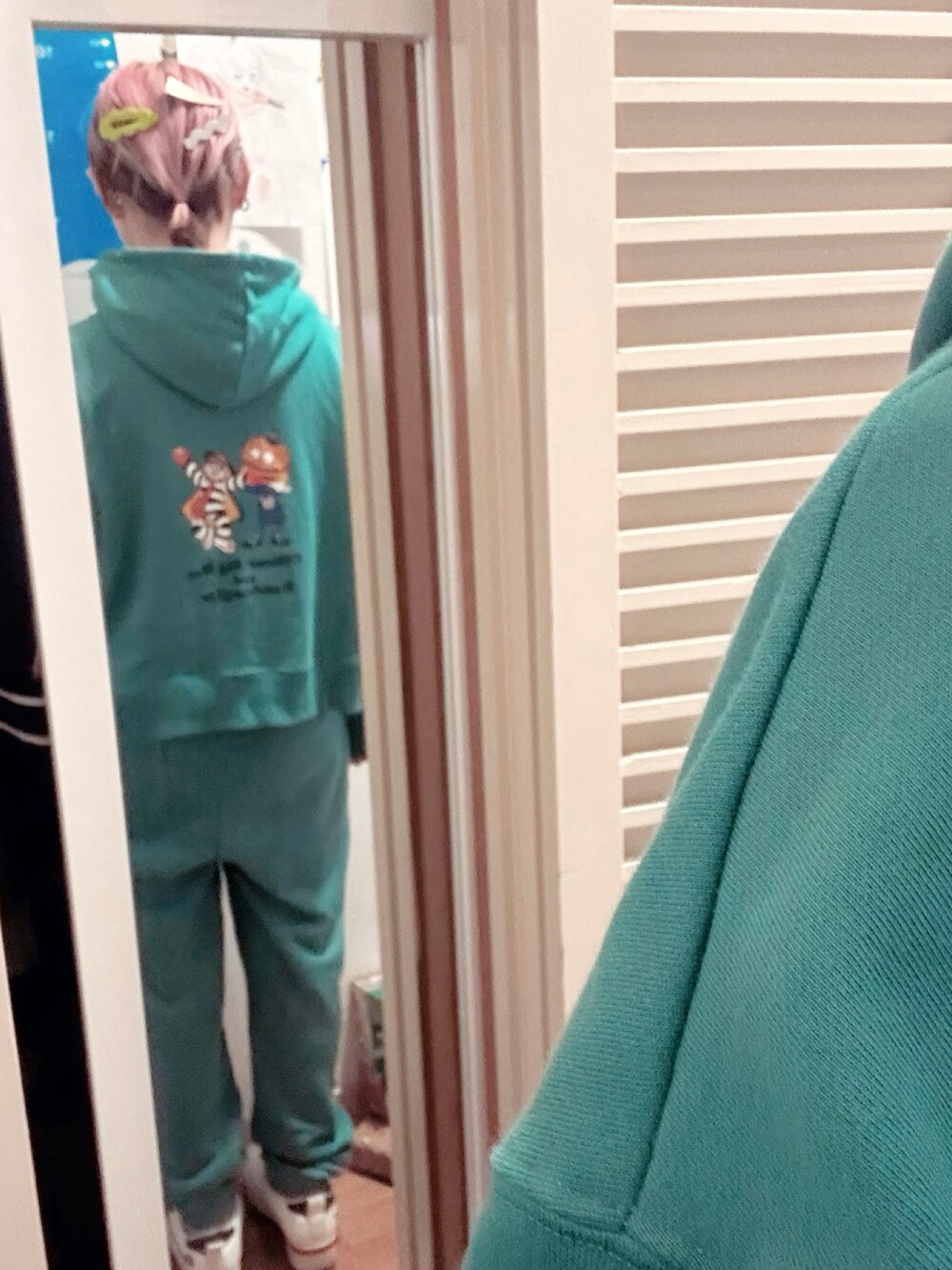 グリーン系のスウェット、グリーン系のスウェットパンツ、ベージュ系のスニーカーを着用したレディースの冬コーディネートの3枚目の写真