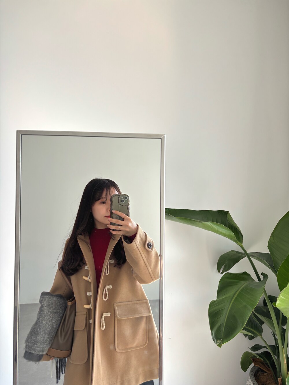 ベージュ系のダッフルコート、ブラック系のデニムパンツを着用したレディースの秋コーディネートの2枚目の写真